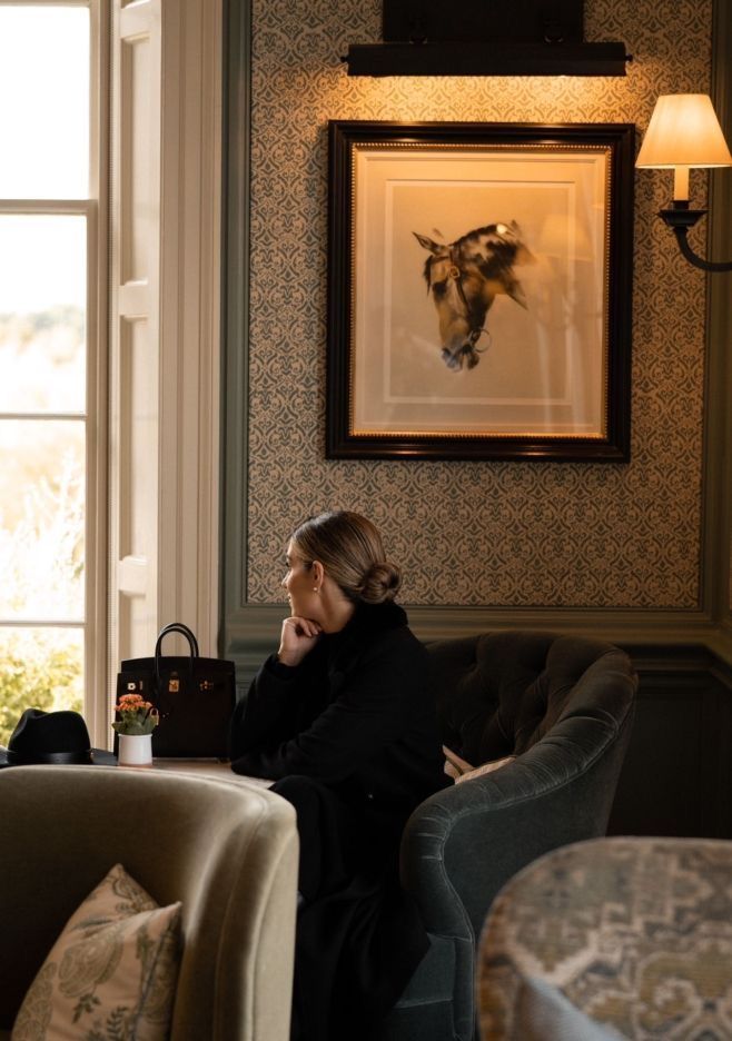 A professional seated in a classic, warmly lit lounge